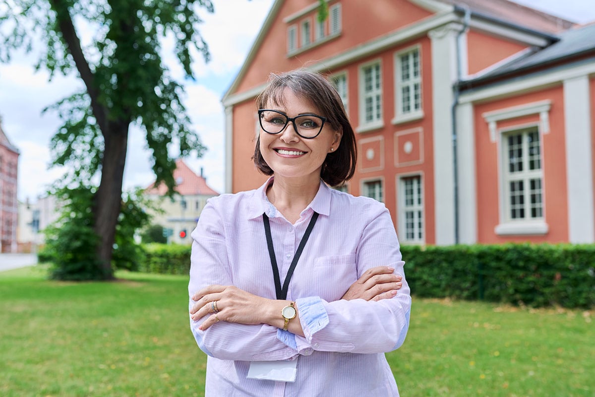 Teacher smiling, confident female staff looking at camera Teacher smiling, confident female staff looking at camera